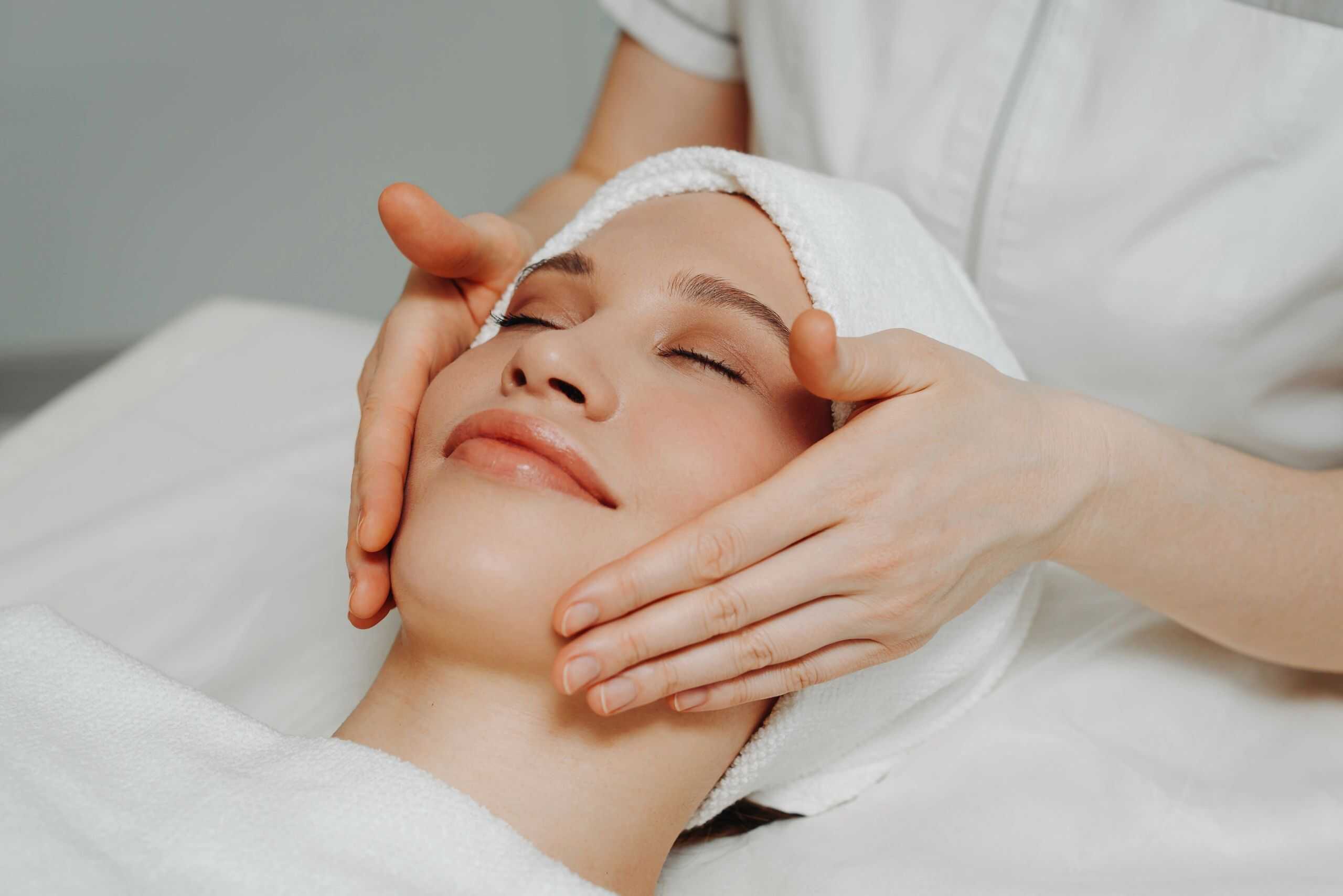 Esthetician performing a relaxing facial massage in a spa treatment room
