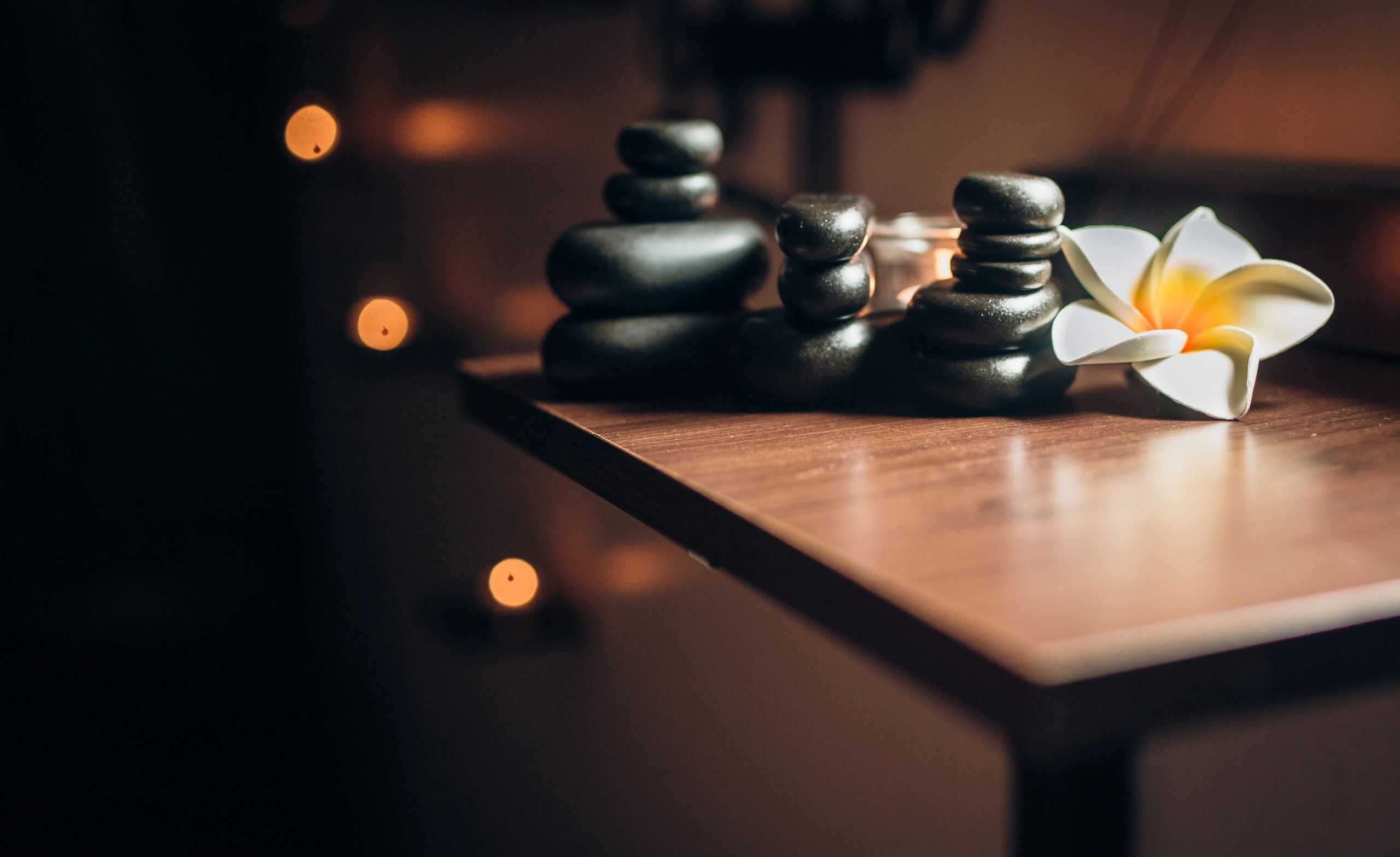 Relaxing spa setting with candles and massage stones